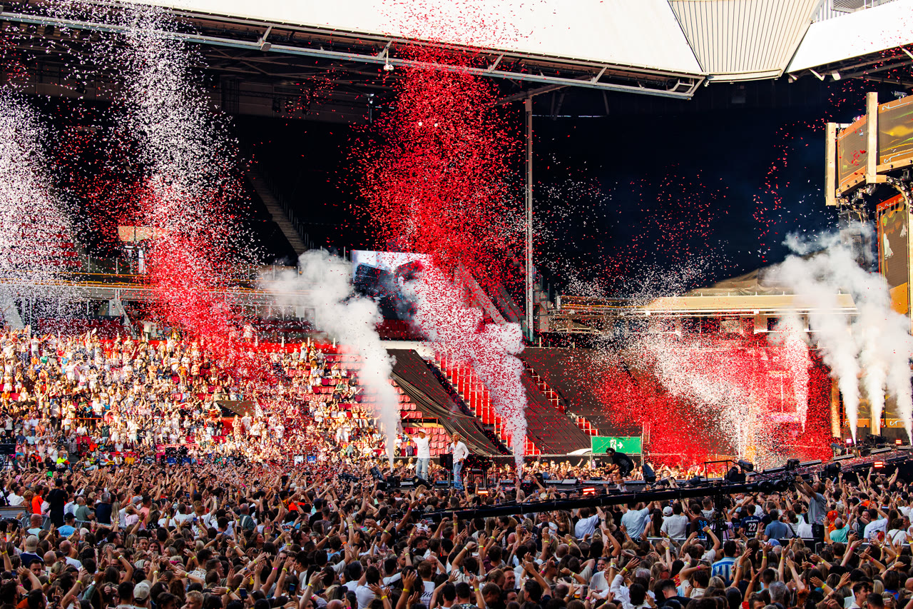 Publiek onder een regen van rode en witte confetti